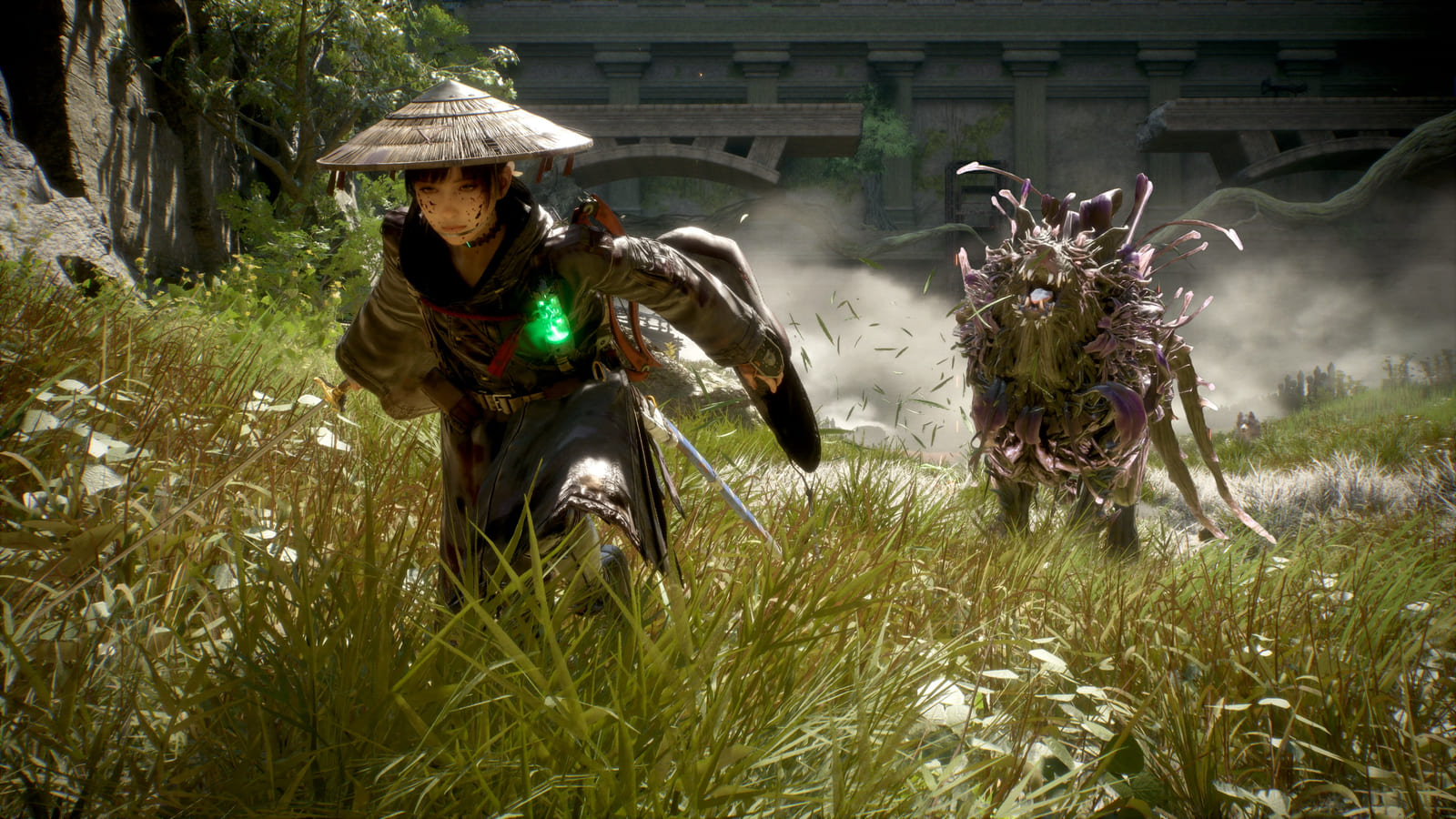 Emma lunging through tall grass with her sword drawn and a green glowing charm at her chest, facing a shaggy plant-covered creature bristling with purple petals